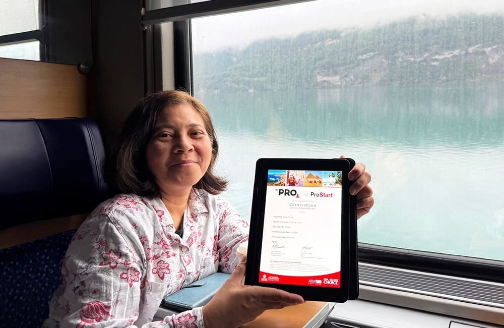 TC ProStart graduate Emilie Yu-Yap from Global Travel Co holds tablet with certificate on ship.
