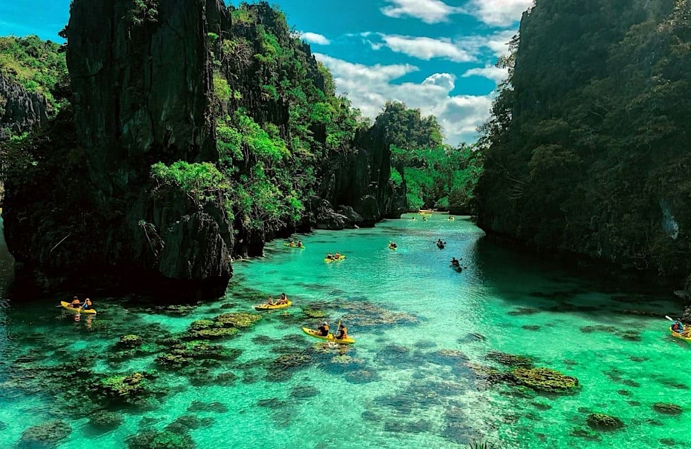 Aussie Travellers kayaking through El Nido’s turquoise lagoons in Palawan, one of the Philippines’ most in-demand destinations for Australians.