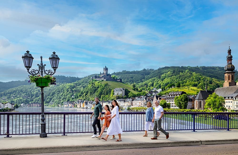 Multigenerational family walking together in Cochem with Reichsburg Castle on Moselle River in Germany.