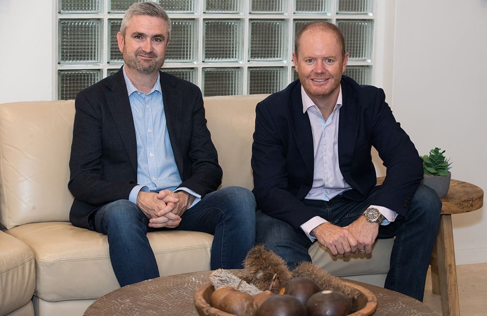 Entire Travel Group Sales & Marketing Director Greg McCallum and Managing Director Brad McDonnell seated on couch. Consolidated Travel Group stakeholder