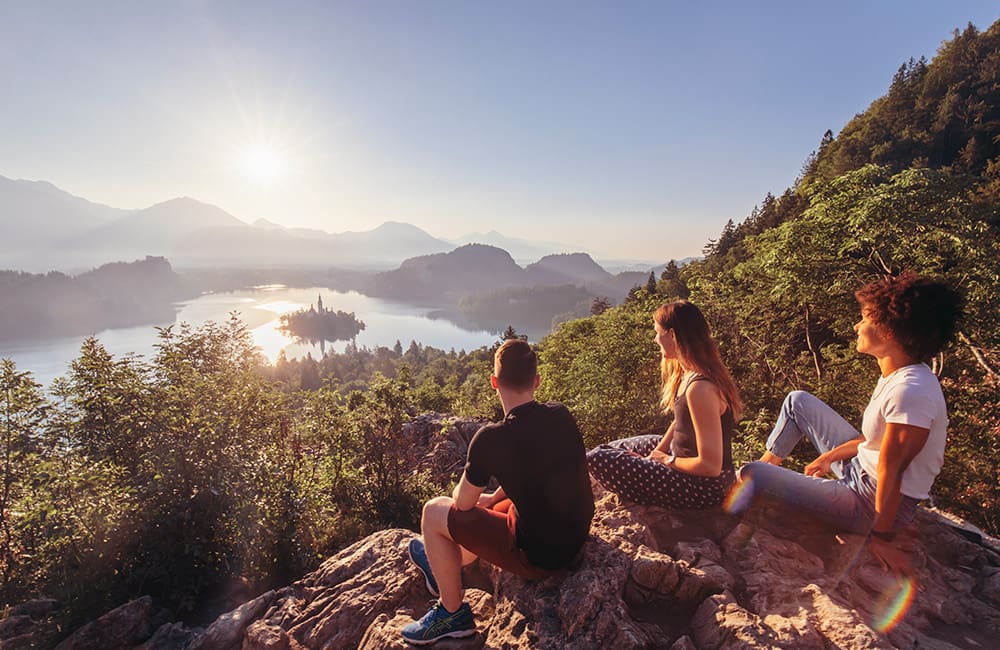 Three travellers at Lake Bled in Slovenia. Image: Intrepid Travel