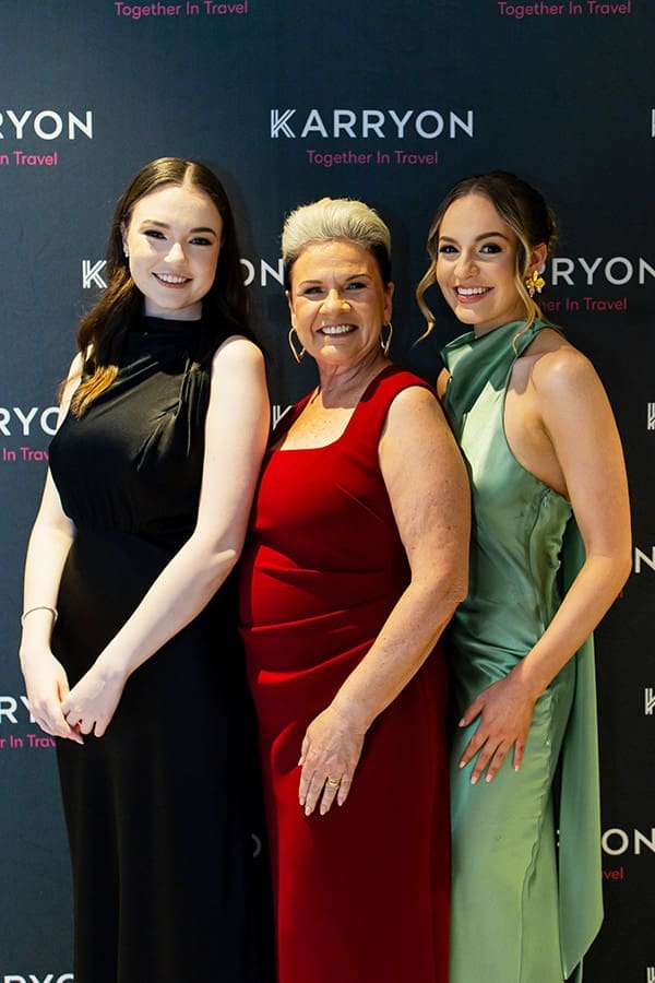 3 women in formal attire in front of media wall at Karryon Glam Club 2025.