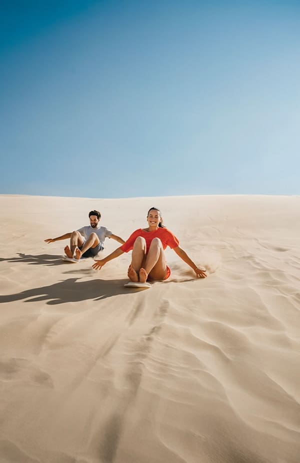 Couple on Stockton Sand Dunes. Image: Destination NSW