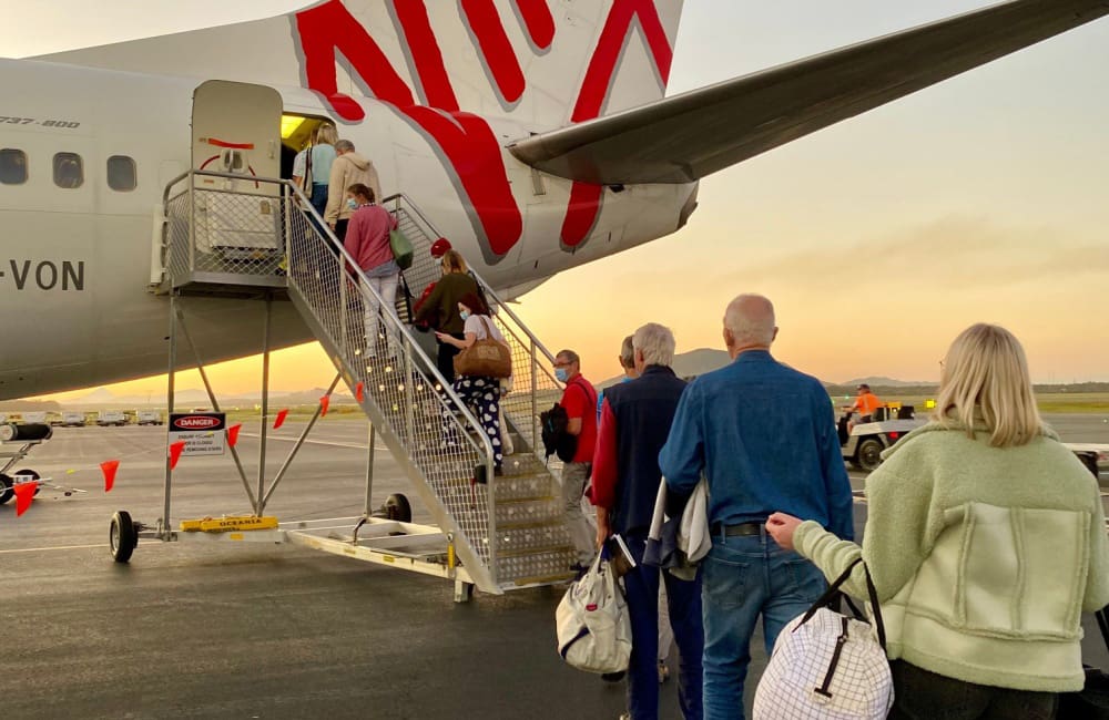 Passengers boarding Virgin Australia aircraft from tarmac.