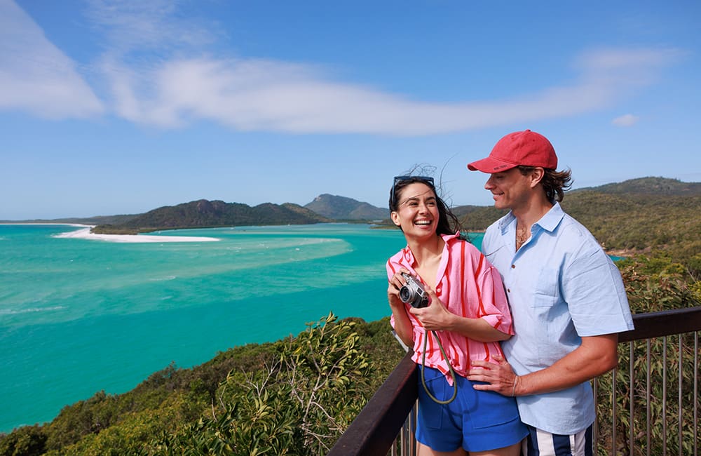 Couple with a camera at a lookout in The Whitsundays – Chief Icon Officer campaign. Image: Shannyn Higgins